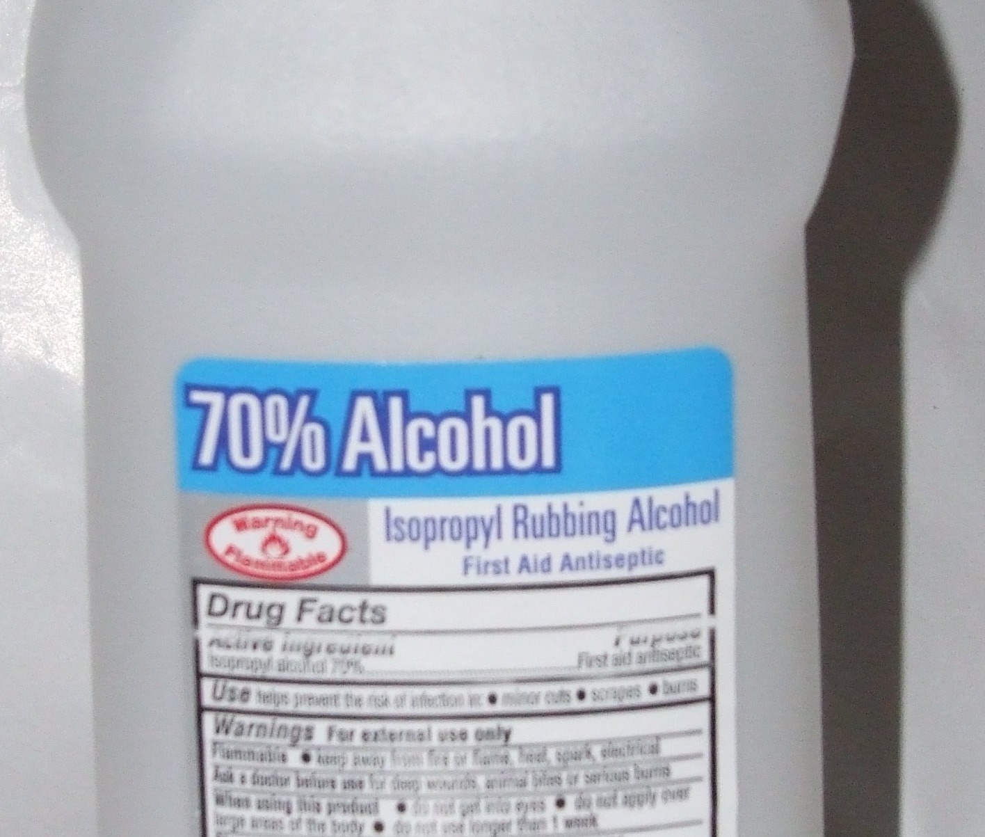 Label of a bottle of 70% isopropyl rubbing alcohol showing a red Warning Flammable symbol and a Drug Facts panel