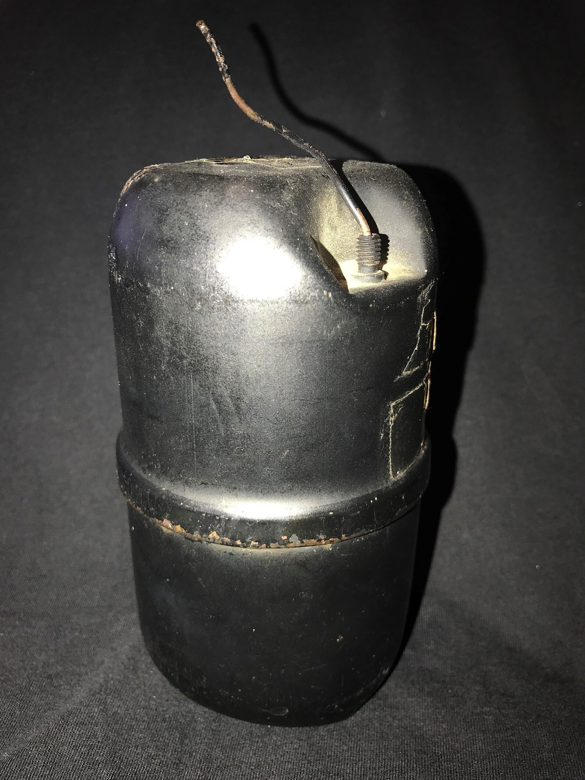 Black metal World War II era aerosol insecticide canister with a short valve tube on top