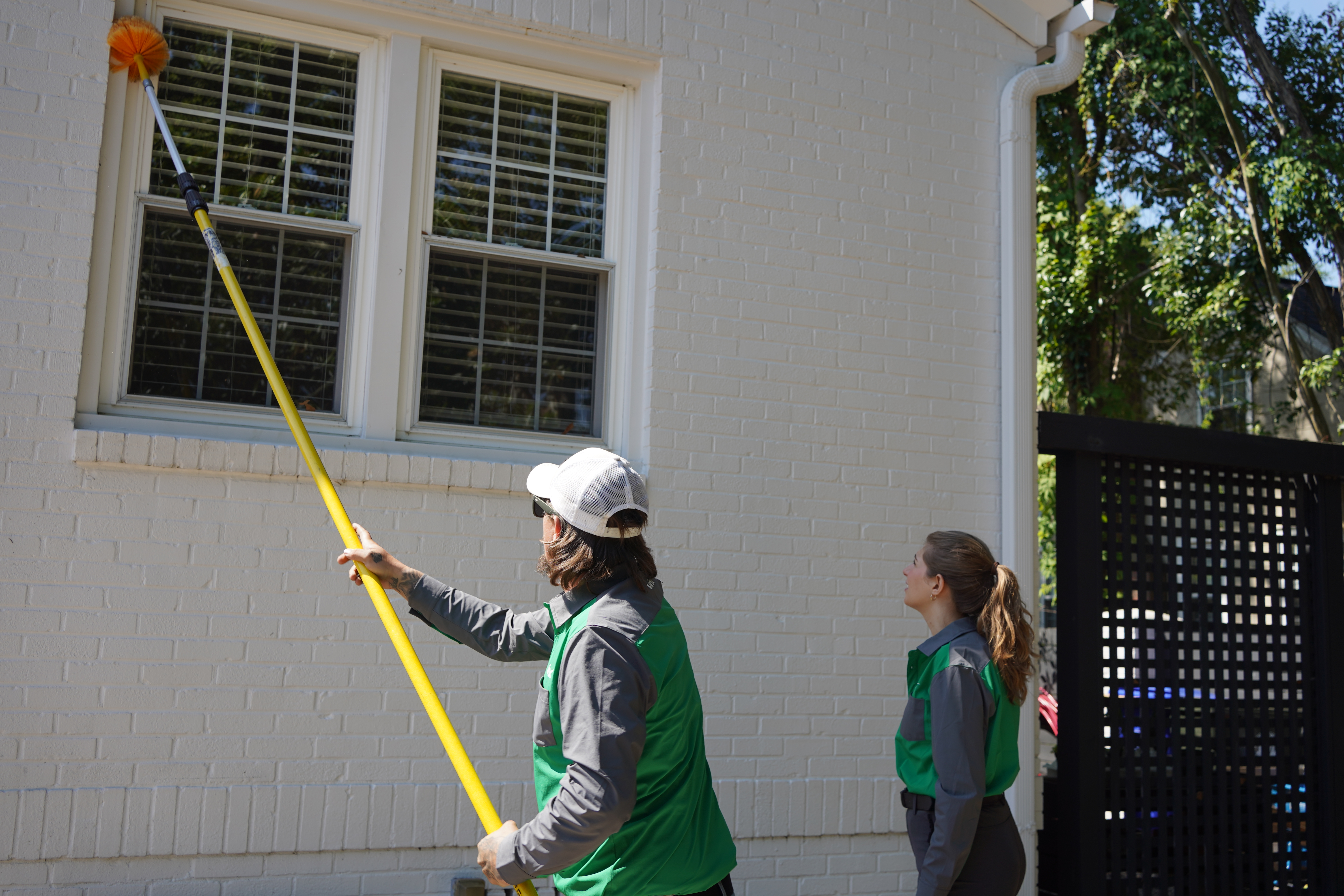 Vinx technician sweeping eaves and treating for wasps in Columbia